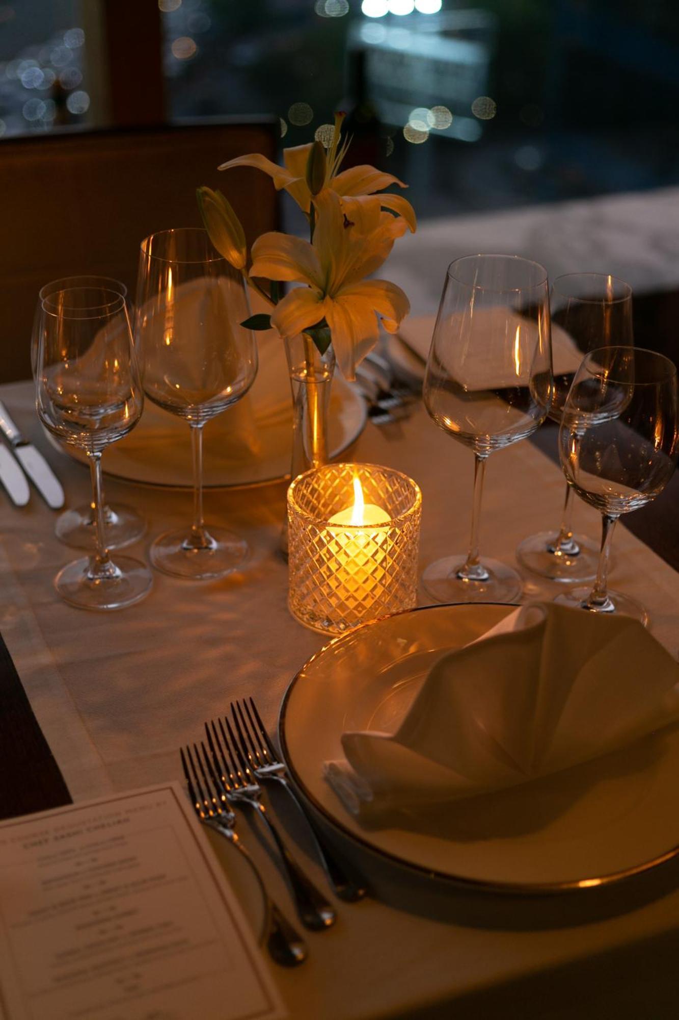 The Leela Ambience Gurugram Hotel & Residences - The Luxury Urban Sanctuary Gurgaon Bagian luar foto A candle on a dinner table