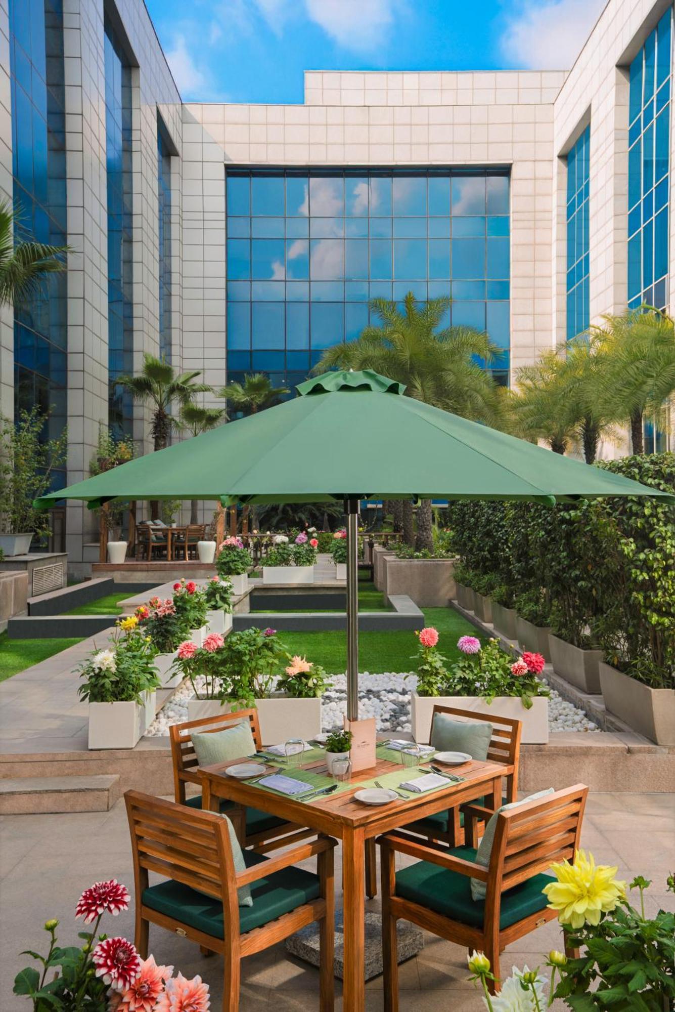 The Leela Ambience Gurugram Hotel & Residences - The Luxury Urban Sanctuary Gurgaon Bagian luar foto A patio umbrella